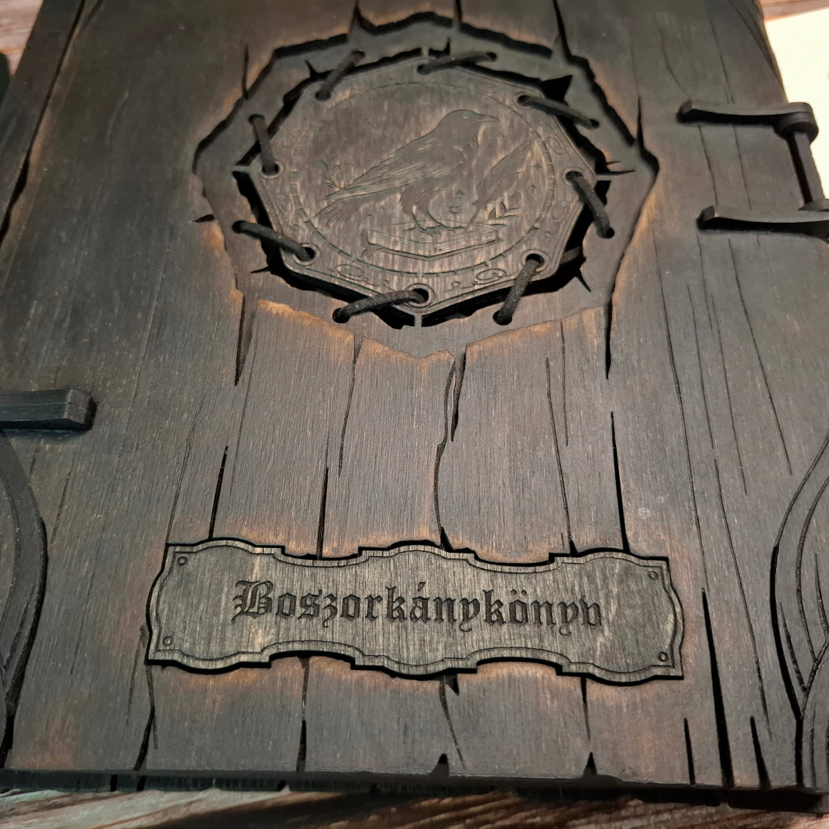 Close-up of the Hungarian “Boszorkánykönyv” engraving on the wooden witch book cover