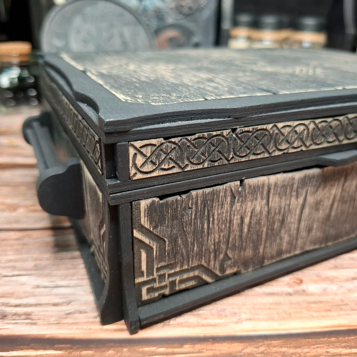 Close-up of the handcrafted Celtic knotwork and wood grain on a Celtic ritual storage box, showcasing the detailed craftsmanship and engraved decorative elements.
