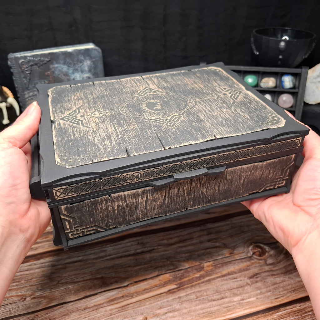 Handcrafted Celtic ritual storage box held in both hands, showcasing its size, engraved wooden lid, and detailed Celtic craftsmanship.
