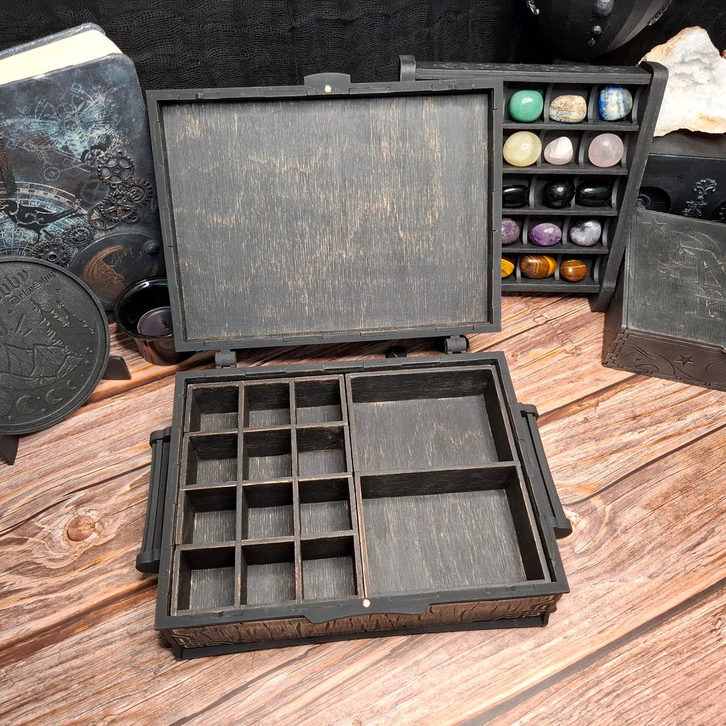 Open handcrafted Celtic ritual storage box featuring removable interior organizers with dedicated compartments for crystals, herbs, small bottles, tarot accessories, and ritual tools.
