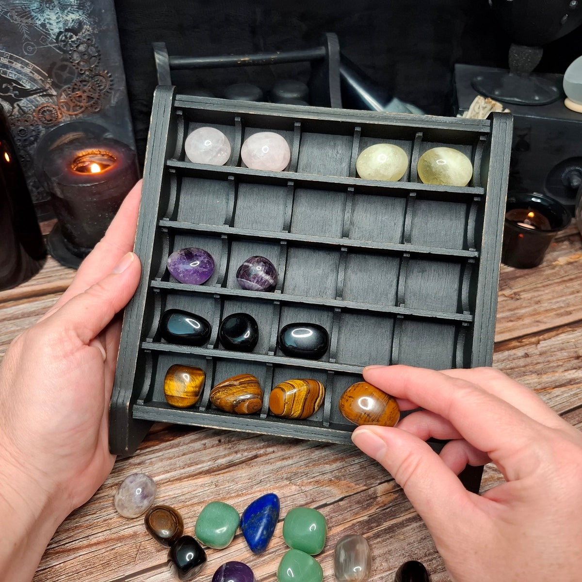 Wooden crystal storage shelf displaying a collection of tumbled crystals and gemstones.
