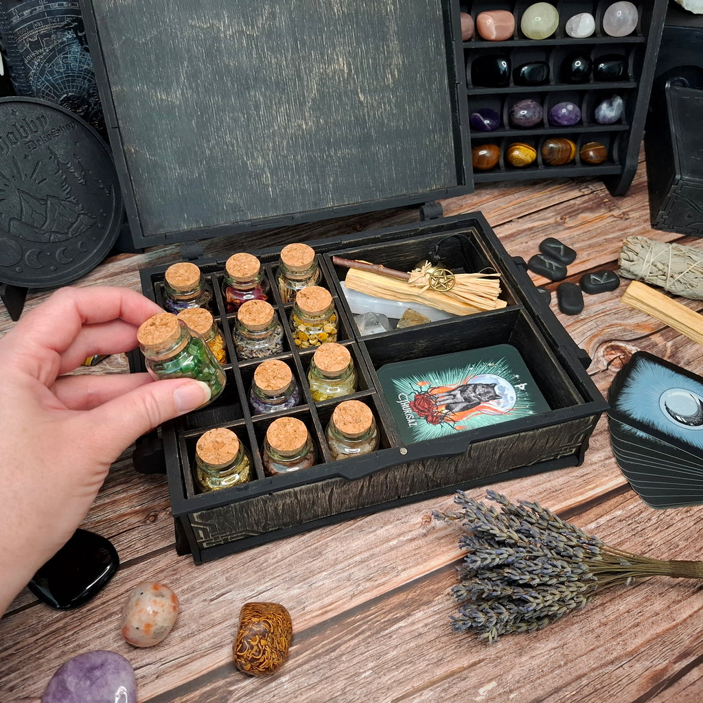 Reaching for a small herb bottle from the removable organizer inside the Celtic ritual storage box, keeping everyday ritual essentials neatly organized and easy to access.
