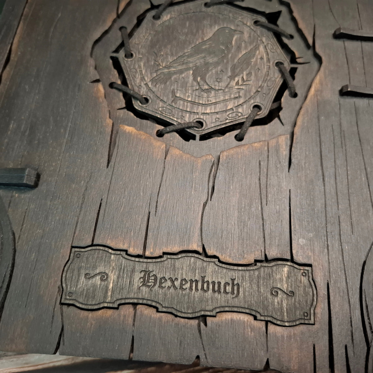 Close-up of the German “Hexenbuch” engraving on the wooden witch book box