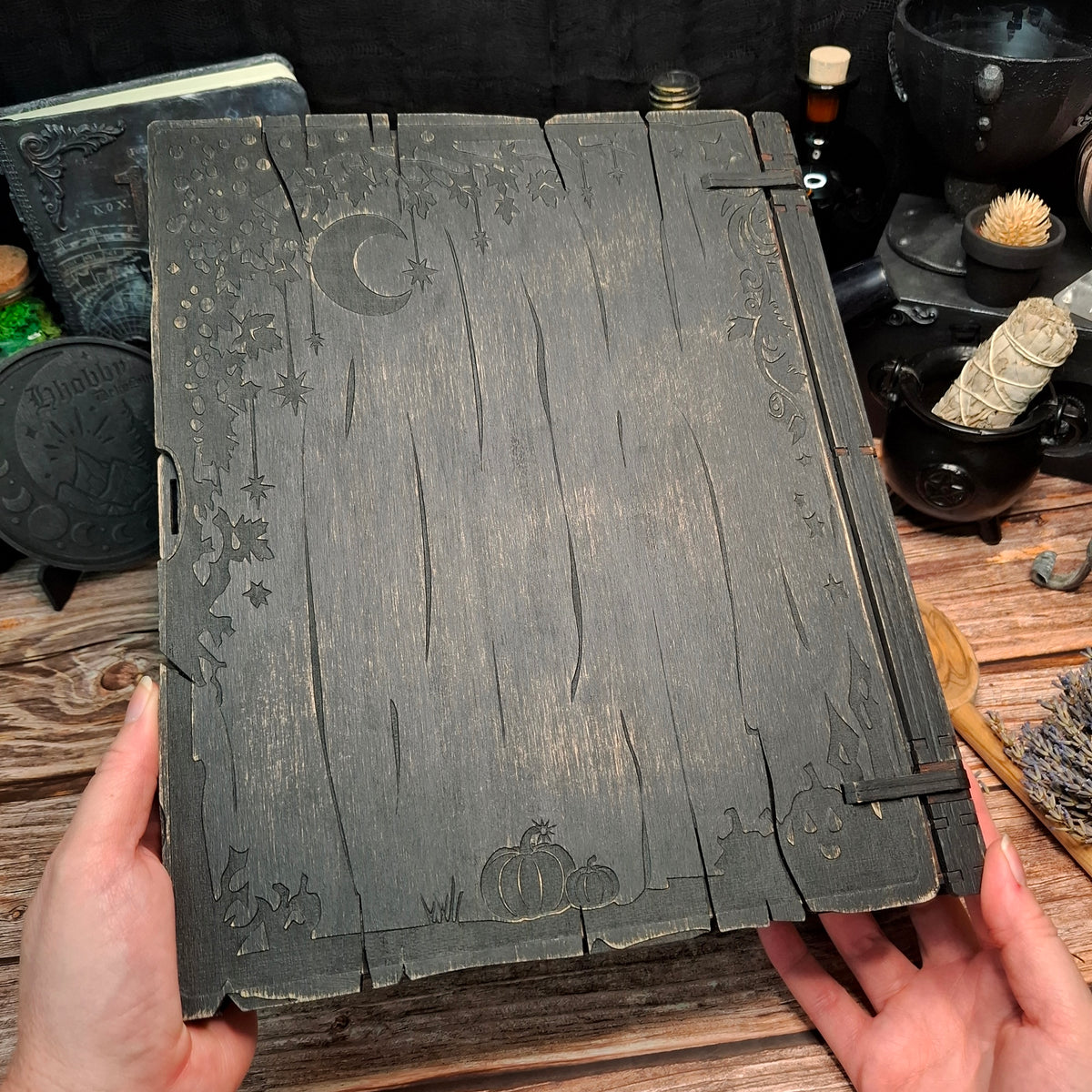 Back cover of the My Spellbound Recipes wooden binder shown in hand