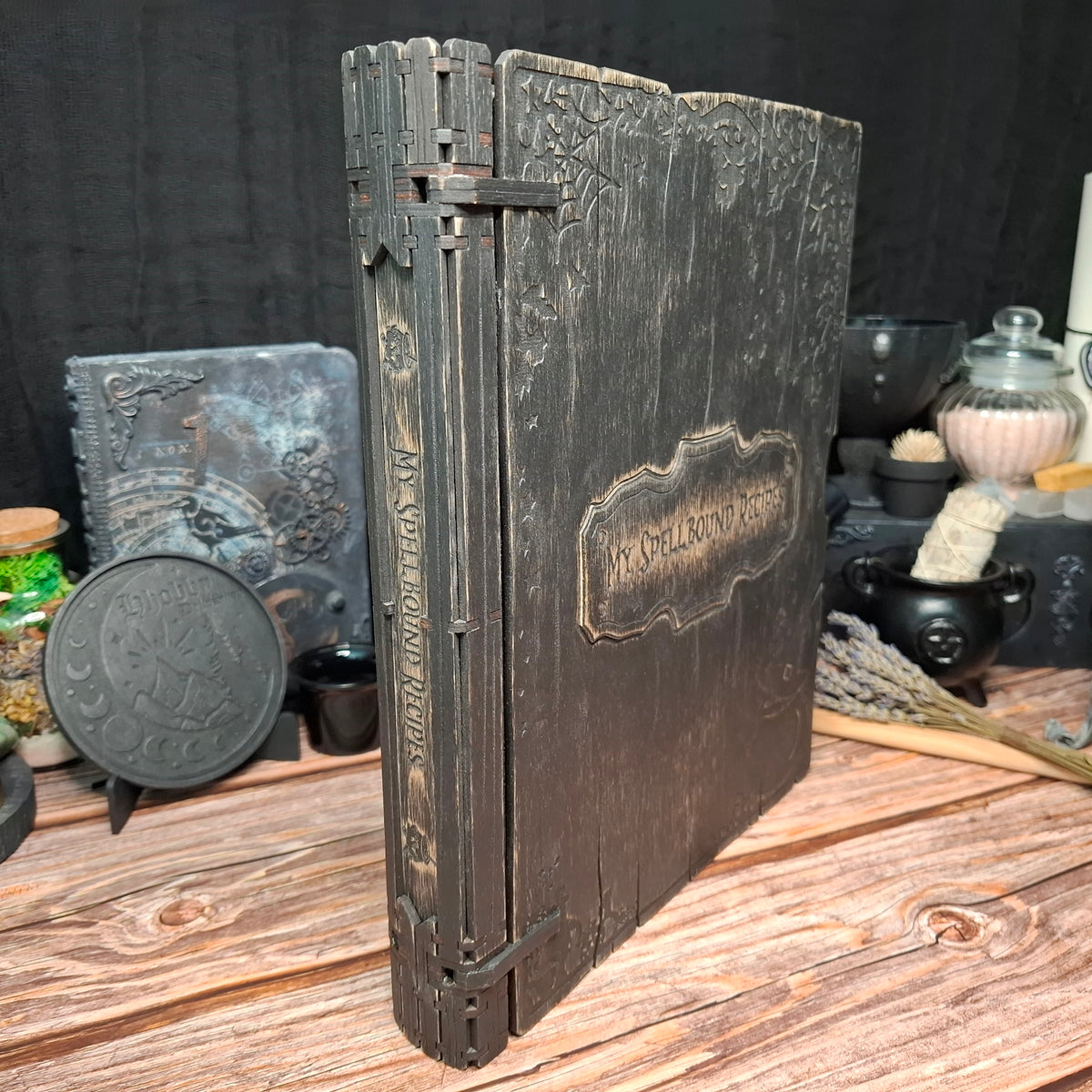 Side view of a handmade wooden recipe binder with grimoire-inspired design