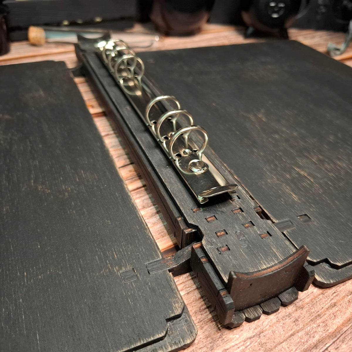 Close-up of the ring binding mechanism inside a handmade wooden recipe binder