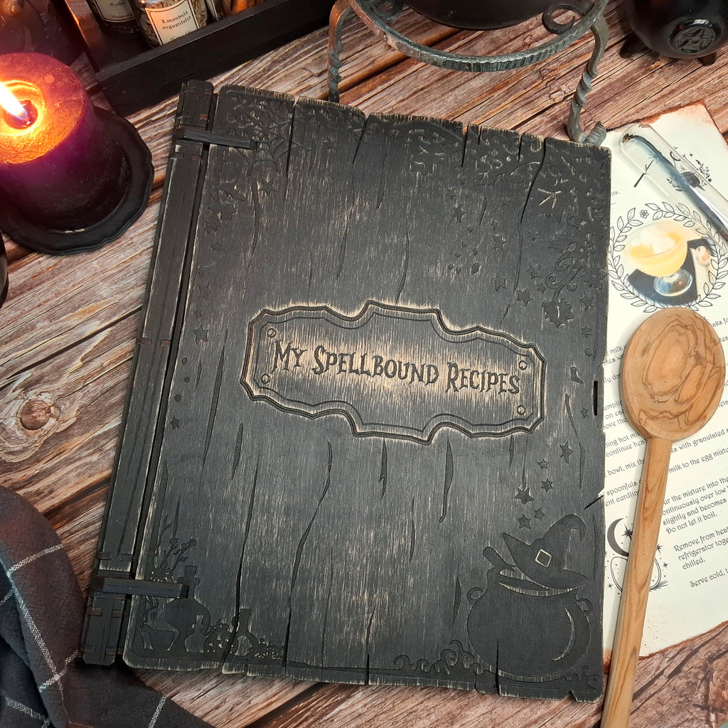 Handmade wooden recipe binder titled My Spellbound Recipes with engraved grimoire-style cover