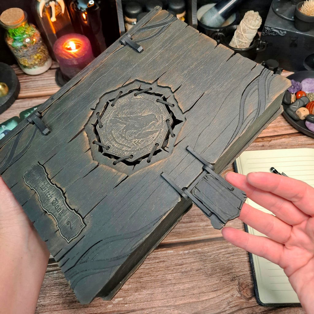 Hands opening a handmade raven witch book storage box