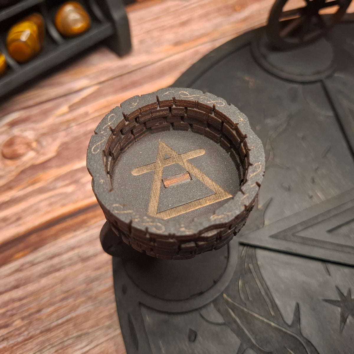 Close-up of engraved pentagram symbol on a handmade wooden ritual candle holder