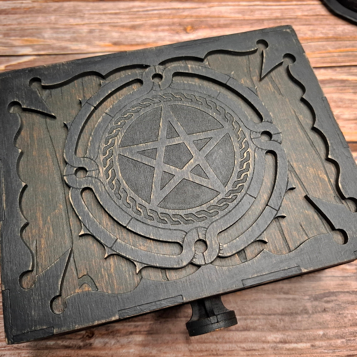 Close-up of the engraved pentagram design on a handmade wooden ritual box lid