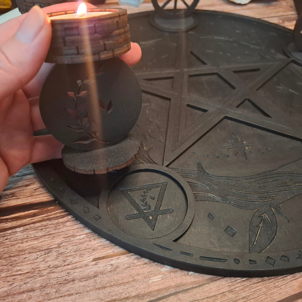 Handmade wooden ritual candle holder held above a pentagram altar tray